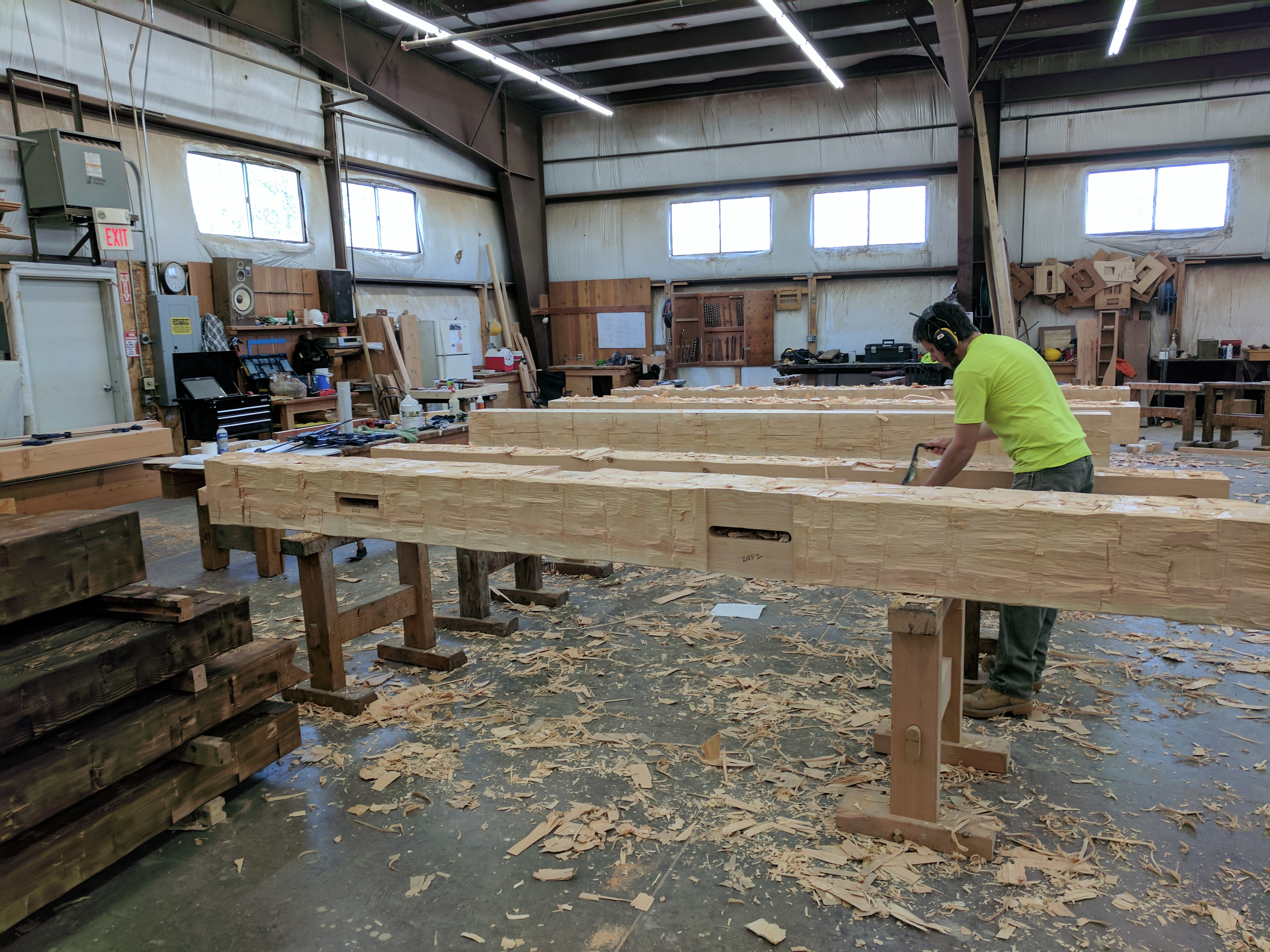 Timber framer Pete adds finishing touches with a draw knife to these hand-hewn timbers.