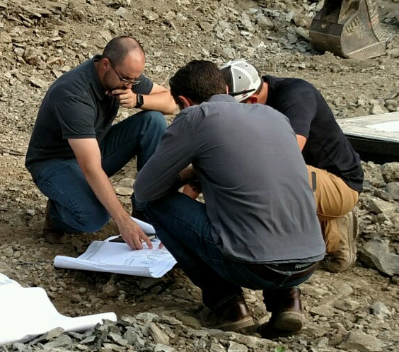 Ty (left) discusses plans on the job site with a few other members of the design/build team.
