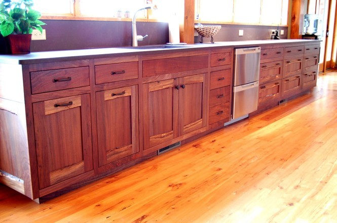 Live edge rails and stiles add more visual interest and personality to a long bank of cabinets in a lake home kitchen.
