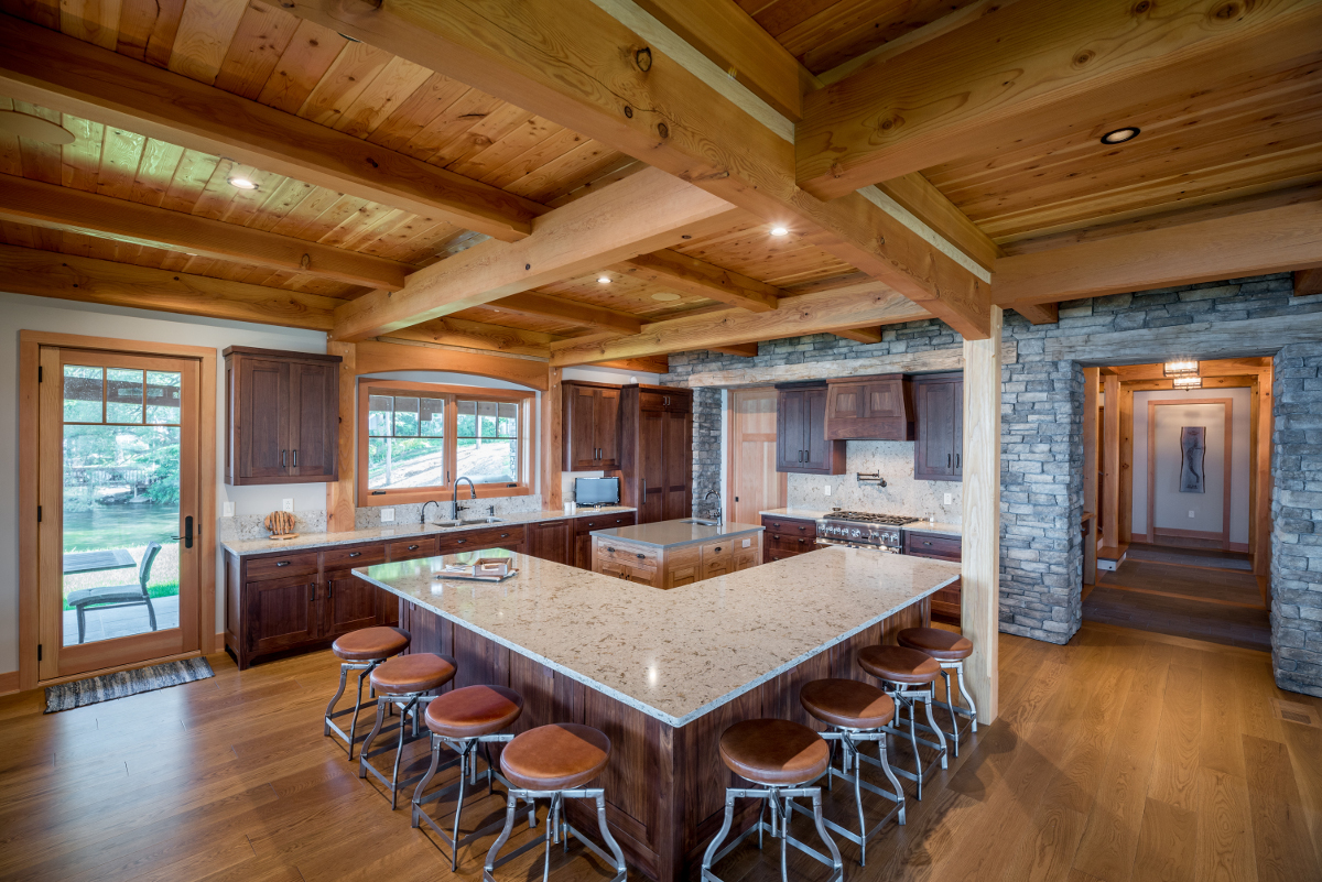 More stone adorns the stove wall and a central island celebrates the character/lighter tones of Hickory.