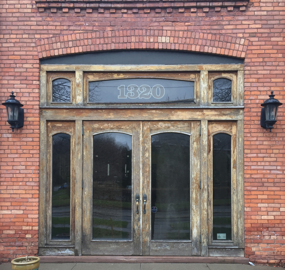 The original weather-worn oak doors on University Ave.