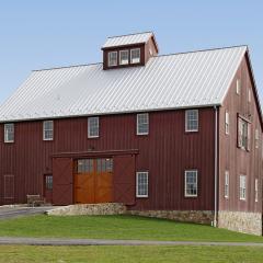 This classic barn design uses glulam beams for a classic look that supports a second floor used to store cars.
